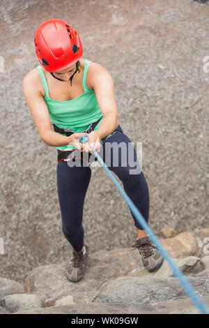 Sportliches Girl Abseilen Felswand Stockfoto