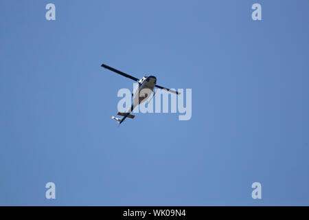 Die italienische Polizei oder polizia Hubschrauber fliegen tief über Gebäude im Sommer in Italien Stockfoto