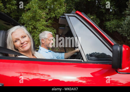 Seite Blick auf älteres paar fahren roten Cabrio Stockfoto