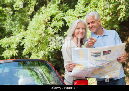 Älteres Paar auf der Suche nach Richtung Lächeln Stockfoto