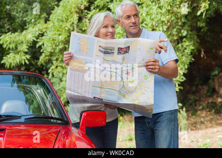 Älteres paar lesen Karte Suche nach Richtung Lächeln Stockfoto