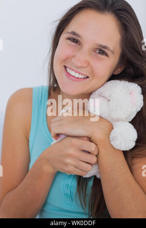 Junge Frau umarmt einen kleinen Teddybär Stockfoto