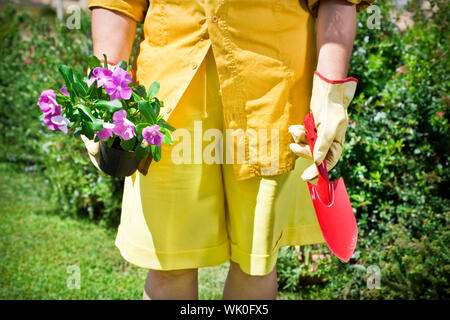 7/8-Ansicht der älteren Frau mit Blumentopf im Garten Stockfoto