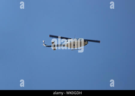 Die italienische Polizei oder polizia Hubschrauber fliegen tief über Gebäude im Sommer in Italien Stockfoto