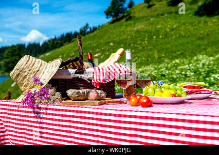 schmeckte Picknick auf dem Rasen in der Nähe von einem See Stockfoto