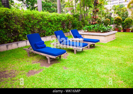 Blaue Chaise lounges in der Nähe von Pool im Luxus-Resort auf dem grünen Rasen Stockfoto