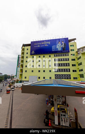 Ein großer Outdoor Plakatwerbung der Prinz Bank hängt auf einem Gebäude über einer Total Tankstelle in städtischen Phnom Penh, Kambodscha. Stockfoto