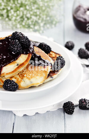 Köstliche goldene Pfannkuchen mit frischen Brombeeren und Blackberry jam. Extrem geringe Tiefenschärfe. Stockfoto