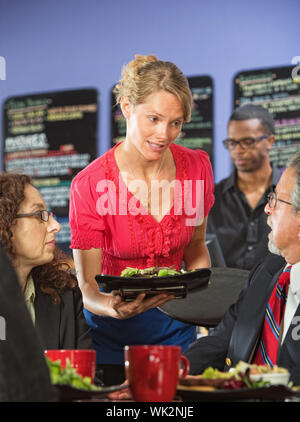 Apologetischen Server bringen Salat, Geschäftsmann verärgert Stockfoto