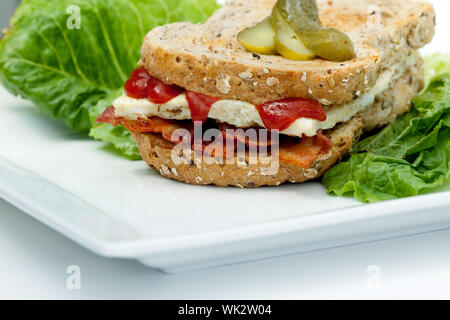 Eine westliche Sandwich (Denver Sandwich) Omelette und Speck auf braunen Toast serviert. Stockfoto