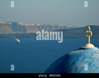 Blick auf Caldera von Santorin mit typischen Kykladen Kirche Dome und fernen Schiff Stockfoto