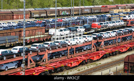 München, Deutschland - Juli 10, 2019: Viele neue Autos auf Bahn autorack Wagen geladen und bereit für den Versand von Fabriken zu Autohandel Stockfoto