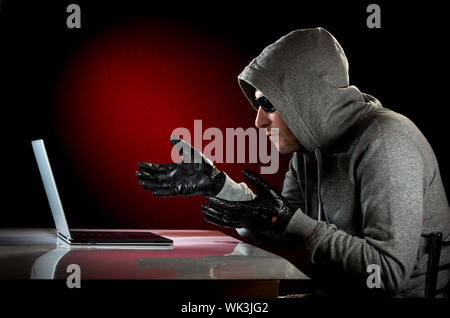 Hacker in einer Sonnenbrille mit Laptop. Stockfoto