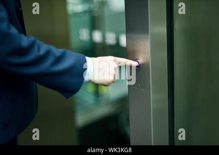 Geschäftsmann, Lift-Taste Stockfoto