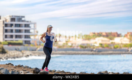 Junge Frau, die auf Trail auf dem Ozean Küste. Gesund joggen lifestyle Hintergrund Stockfoto