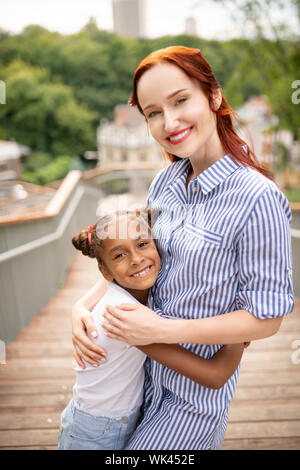 Dunkelhäutige Mädchen freuen, während schließlich Mama in Stockfoto