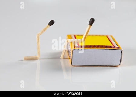 Männliche Gestalt schlägt vor, eine weibliche Gestalt aus Streichhölzern gemacht Stockfoto