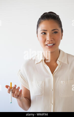 Casual Geschäftsfrau Rauchen eine elektronische Zigarette in Ihrem Büro Stockfoto