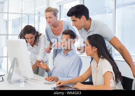 Casual Geschäftsmann mit Kollegen etwas auf dem Computer im Büro Stockfoto