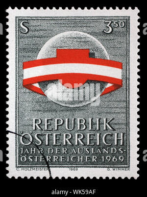 Für die Briefmarke Österreich entnommen wurde, wird in der ganzen Welt durch die Österreichische Fahne ribbon umgeben, Jahr der im Ausland lebenden Österreicher, circa 1969. Stockfoto