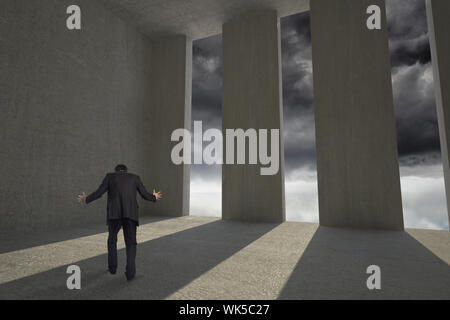 Gestik Geschäftsmann gegen Licht in dunkle Zimmer Stockfoto