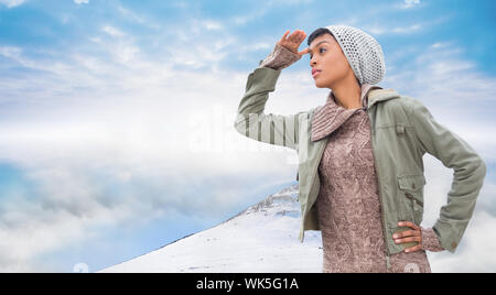 Konzentrierte junge Modell im Winter Kleidung um Beobachtete gegen misty Landschaft Stockfoto