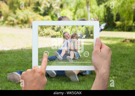 Hand, tablet pc, nette Geschwister im Park sitzen Stockfoto