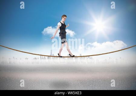 Geschäftsfrau, ein Balanceakt gegen Stadtbild am Horizont Stockfoto