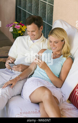 Mann und Frau mit Gadgets auf Terrasse Stockfoto