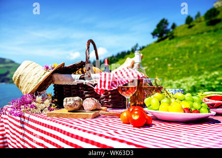 schmeckte Picknick auf dem Rasen in der Nähe von einem See Stockfoto