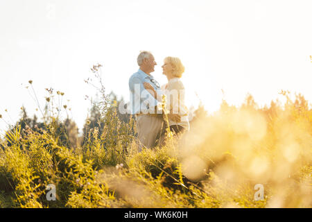 Der Mann und die Frau, beide Senioren, einander umarmen Stockfoto