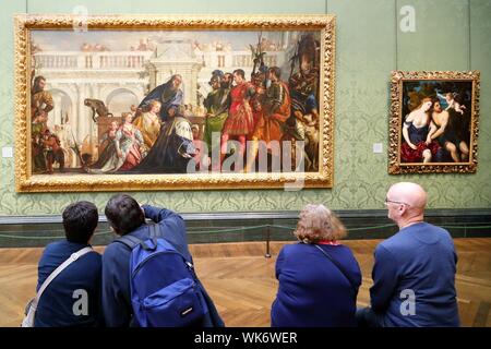 Ein Junge und ein altes Ehepaar sitzt im Ausstellungsbereich und Studium eine Arbeit von Paolo Veronese in der Nationalgalerie, Trafalgar Square, London, UK Stockfoto