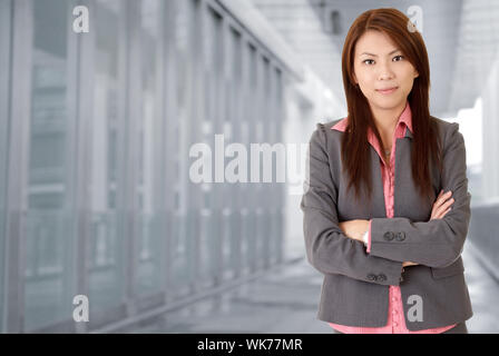 Junge attraktive Geschäftsfrau im Korridor des modernen Gebäudes im Aussenbereich. Stockfoto