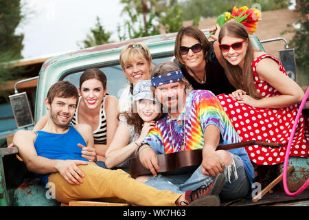 Groovy Gruppe auf der Rückseite LKW lächelnd Stockfoto