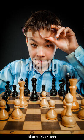 Wunderkind spielen Schach. Lustige Nerd Boy. Stockfoto
