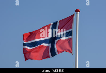 Norwegische Flagge schwenkten auf der Wind gegen den blauen Himmel Stockfoto