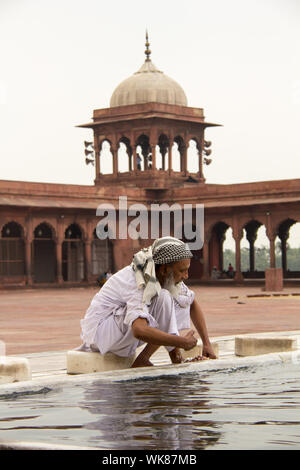 Senior woman führen rituelle Gebetswaschung vor Namaz in einer Moschee Jama Masjid, Alt-Delhi, Indien Stockfoto