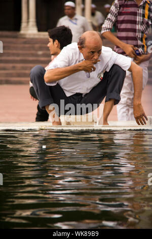 Senior woman führen rituelle Gebetswaschung vor Namaz in einer Moschee Jama Masjid, Alt-Delhi, Indien Stockfoto