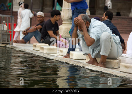 Senior woman führen rituelle Gebetswaschung vor Namaz in einer Moschee Jama Masjid, Alt-Delhi, Indien Stockfoto