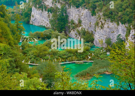 Fußgängerbrücke über türkisfarbenen See Stockfoto