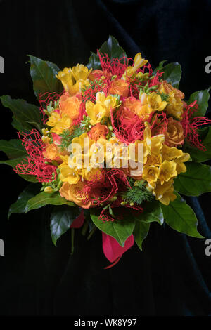 Frischer Frühling Ferienwohnung Strauß gelber Freesien und Rosen auf schwarzem Hintergrund, Geburtstag Konzept, den internationalen Tag der Frau und zum Valentinstag Stockfoto