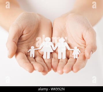 Nahaufnahme eines Womans schalenförmige Hände mit Papier-Mann-Familie Stockfoto
