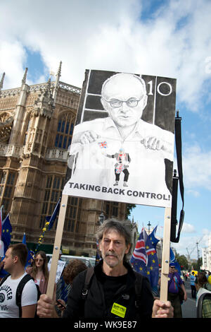 Protest im Parlament Platz. Ein Künstler mit seiner Zeichnung von Dominic Cummings, Chief Boris Johnson's Berater, als Puppenspieler Manipulation von Boris Johnson Stockfoto