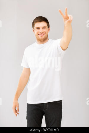 Mann zeigt Sieg oder Peace-Zeichen Stockfoto