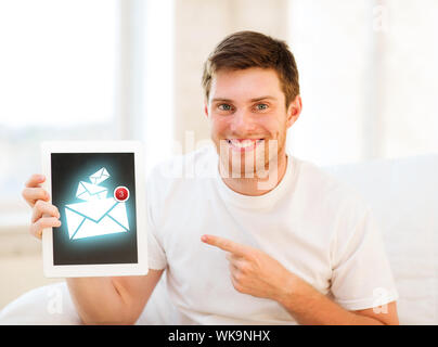 Mann, der Tablet-pc mit e-Mail-Zeichen zu Hause hält Stockfoto