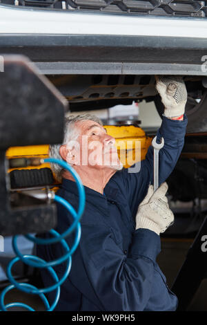 Altes Auto Mechaniker in der Wartung oder Inspektion des Autos vor der Hauptuntersuchung Stockfoto