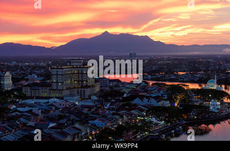 Brennende rote Himmel und Wolken über Guning Serapi Berge bei Sonnenuntergang in Kuching, Sarawak, Malaysia Stockfoto