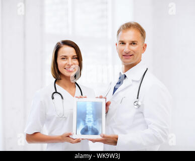 zwei Ärzte, die x-ray auf tablet-pc Stockfoto