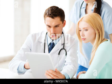 Gesundheitswesen, Medizin und Technologie - Arzt zeigt etwas geduldig auf Tablet-pc im Krankenhaus Stockfoto