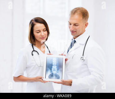 zwei Ärzte, die x-ray auf tablet-pc Stockfoto